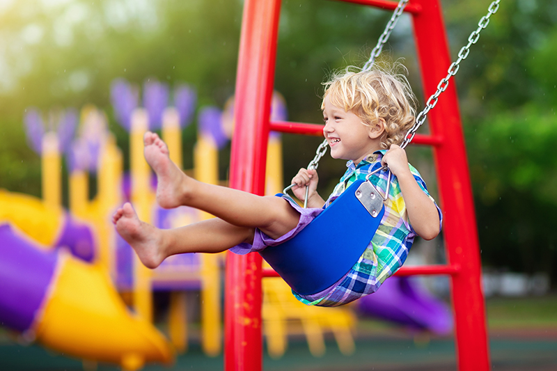 child,playing,on,outdoor,playground,in,rain.,kids,play,on